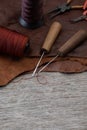 Awl with wooden handle and nylon thread placed on leather and old wooden floors. Royalty Free Stock Photo