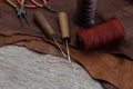 Awl with wooden handle and nylon thread placed on leather and old wooden floors. Royalty Free Stock Photo