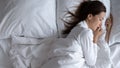 Awoken lonely scared woman lying in bed alone, top view Royalty Free Stock Photo