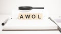 awol word concept. wooden cubes, notepad, pen and business charts Royalty Free Stock Photo