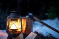 Axe, firewood and lantern in the wilderness