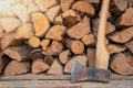 Axe in front of a stack of wood in a woodshed. Natural background. Royalty Free Stock Photo
