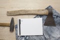 An axe and a hammer on his jeans and a white notebook on the top Royalty Free Stock Photo
