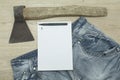 An axe and a hammer on his jeans and a white notebook on the top Royalty Free Stock Photo