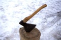 An axe stuck in a log in front of basket with logs fire Royalty Free Stock Photo