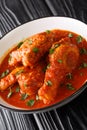 Ayam Masak Merah Delicious fried chicken marinated with turmeric and simmered in a mildly spiced tomato gravy close-up in a bowl.