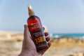 Hand holds Garnier Ambre Solaire sunscreen oil tanning spray closeup Royalty Free Stock Photo