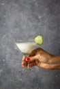 Ayran with dill in a martini glass with a cucumber slice in a woman`s hand