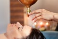 Ayurveda massage alternative healing therapy.beautiful caucasian female getting shirodhara treatment lying on a wooden table in