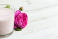 Ayurvedic drink pink milk or matcha. A glass of refreshing cocktail stands on a wooden white background. Nearby lies a Royalty Free Stock Photo