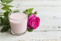 Ayurvedic drink pink milk or matcha. A glass of refreshing cocktail stands on a wooden white background. Nearby lies a Royalty Free Stock Photo