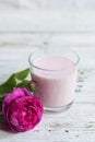 Ayurvedic drink pink milk or matcha. A glass of refreshing cocktail stands on a wooden white background. Nearby lies a Royalty Free Stock Photo