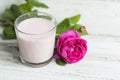 Ayurvedic drink pink milk or matcha. A glass of refreshing cocktail stands on a wooden white background. Nearby lies a Royalty Free Stock Photo