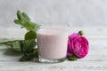 Ayurvedic drink pink milk or matcha. A glass of refreshing cocktail stands on a wooden white background. Nearby lies a Royalty Free Stock Photo