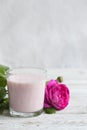 Ayurvedic drink pink milk or matcha. A glass of refreshing cocktail stands on a wooden white background. Nearby lies a Royalty Free Stock Photo