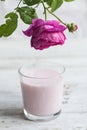 Ayurvedic drink pink milk or matcha. A glass of refreshing cocktail stands on a wooden white background. Nearby lies a Royalty Free Stock Photo