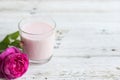 Ayurvedic drink pink milk or matcha. A glass of refreshing cocktail stands on a wooden white background. Nearby lies a Royalty Free Stock Photo