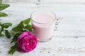 Ayurvedic drink pink milk or matcha. A glass of refreshing cocktail stands on a wooden white background. Nearby lies a Royalty Free Stock Photo