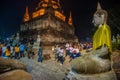 Buddhists people walking with lighted candles in hand around a ancient temple