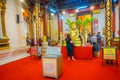 AYUTTHAYA, THAILAND, FEBRUARY, 08, 2018: Unidentified people walking close to a golden budha statue covered with a
