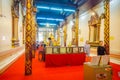 AYUTTHAYA, THAILAND, FEBRUARY, 08, 2018: Unidentified people walking inside of a building close to a golden budha statue