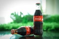 Ayutthaya, Thailand-25June2020: Coca-Cola Classic in a glass bottle and can on dark toned cement Background. Coca Cola, Coke is th