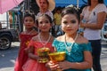 Wedding ceremony on the street. Three little Thai girls with make-up and in elegant dresses hold flowers