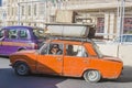 Azerbaijan, Baku-April 10, 2018; An old rusty car of the Fiat Lada model carries old scrap metal on the roof trunk . The driver of Royalty Free Stock Photo