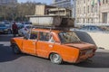 Azerbaijan, Baku-April 10, 2018; An old rusty car of the Fiat Lada model carries old scrap metal on the roof trunk . The driver of Royalty Free Stock Photo