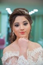 The bride puts her hand on her shoulder and takes a picture at the wedding. Wedding photo session in a beauty salon . The bride
