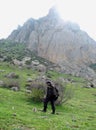 An old shepherd walks with his staff through the mountains of Azerbaijan