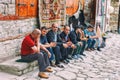 Azeri Men sitting and talking in the Street on cobblestone Huseynov street, the main street of Lahic mountainous village of Azerba