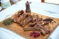 Azeri national antrikot kebab on a wooden board . Dry Satureja . Dried savory spice Satureja hortensis . Copper pepper dish .