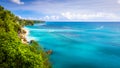 Azure beach with rocky mountains and clear water of Indian ocean at sunny day