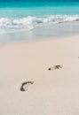 Azure ocean waves rolling on the beach with foot prints Royalty Free Stock Photo