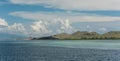 Azure stranded ocean lapping at the foot of rocky hills under a