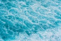 The azure surface of the ocean. Waves break at the shore. Texture of the water surface near the shore above the coral reef. Aerial Royalty Free Stock Photo