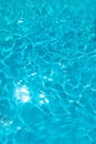 Azure transparent texture of water in a blue pool with splashes from the sun