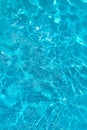 Azure transparent texture of water in a blue pool with splashes from the sun