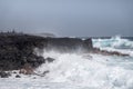 Azure waves crash on black lava coast at Kaimu Beach, Hawaii, USA Royalty Free Stock Photo