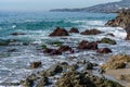 Azure waves crashing over colorful rocks in California