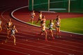 Female Runners Competing in 800m Race Under Captivating Sunset Light: Track and Field Event