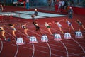 Female Sprinters Kick Off 100m Race from the Starting Point at Track and Field Meet for Royalty Free Stock Photo