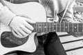 B&W - Young man playing acoustic guitar close up outdoors