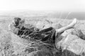B&W young woman lying back in high grass Kineret lake view.