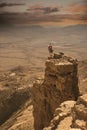 BA mountain climber stands on a cliff, with a rope and helmet, before abseiling. Beautiful dramatic view of the desert Royalty Free Stock Photo