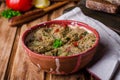 Babaganoush with tomatoes, cucumber and parsley - arabian eggplant dish or salad on wooden background. Selective focus
