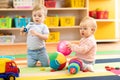 Babies boy and girl playing on floor with toys. Kids toddlers in creche or nursery