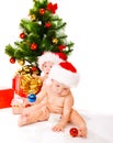 Babies beside Christmas tree Royalty Free Stock Photo