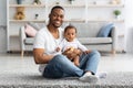 Babies Development. Portrait Of Happy Black Father With Little Baby On Lap Royalty Free Stock Photo